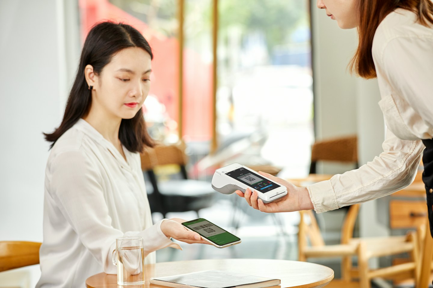 Customer scans a QR code for mobile payment at a cafe.